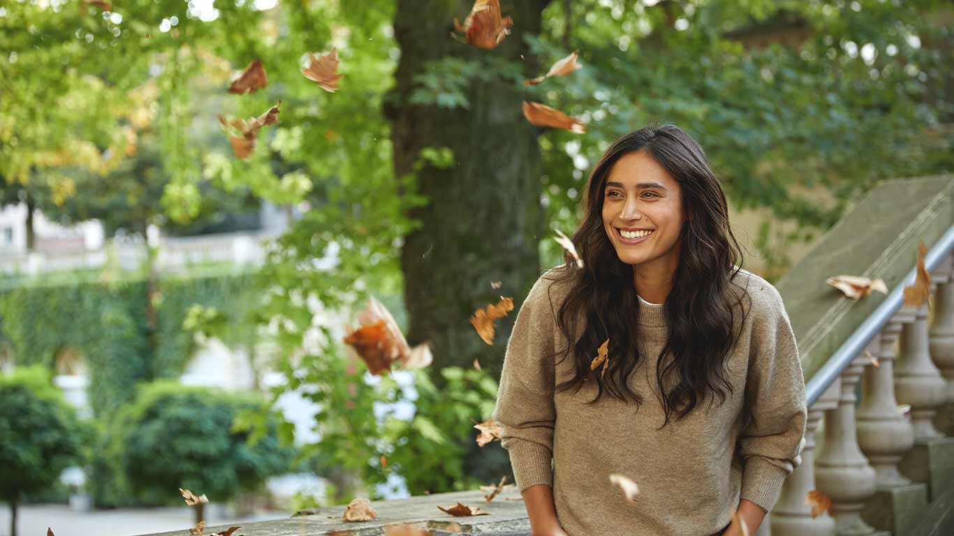 Vrouw in trui geniet van de natuur.